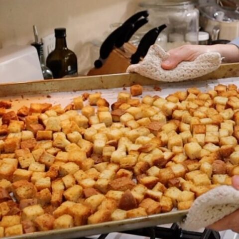 fresh from the oven, crispy brown baked homemade croutons on a baking sheet